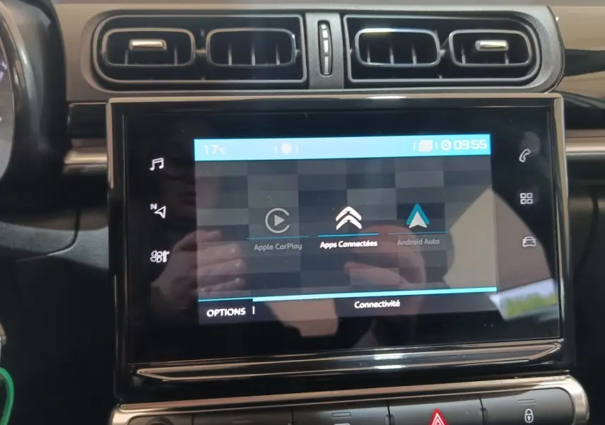 Vue rapprochée de l'écran tactile central noir du tableau de bord d'une Citroën C3 blanche, affichant Apple CarPlay et Android Auto.