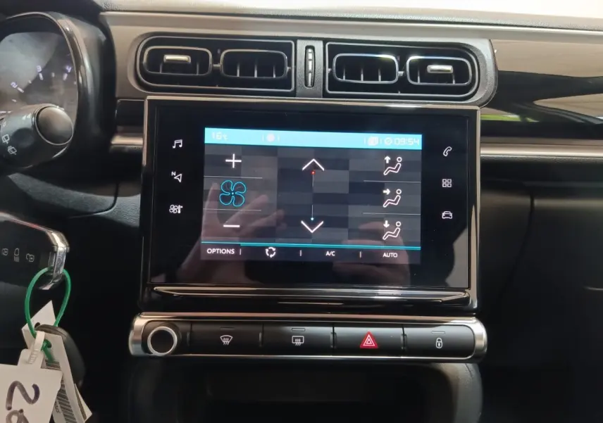 Vue rapprochée de l’écran tactile central et des commandes de climatisation d’une Citroën C3 blanche de 2020.