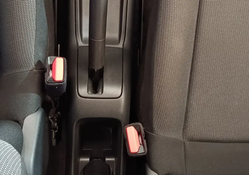 Vue plongeante sur la console centrale noire avec frein à main manuel et sièges tissu gris de la Citroën C3.