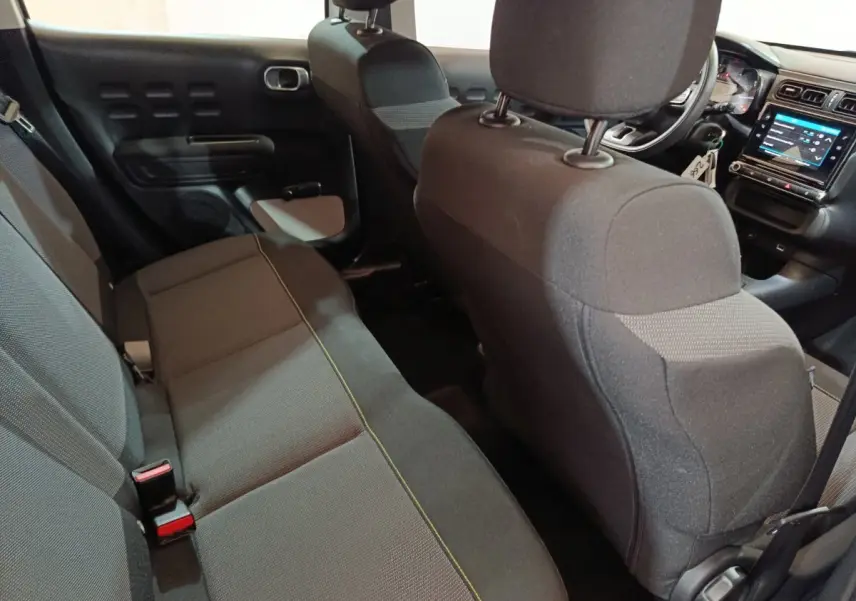 Vue intérieure arrière montrant la banquette noire et le tableau de bord avec écran tactile de la Citroën C3 2020.