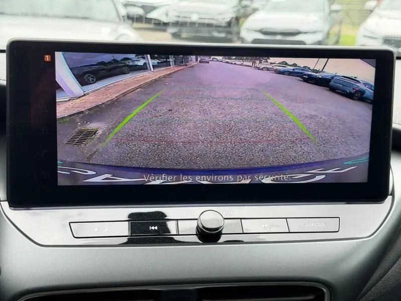 Vue écran caméra de recul du Nissan Juke 2025 bleu magnétique, montrant l'arrière et le sol du parking.
