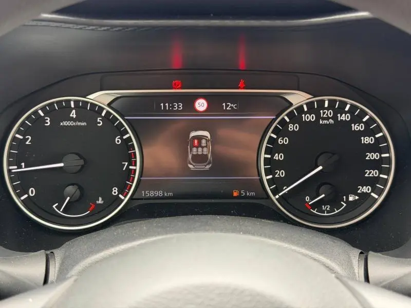 Vue rapprochée du tableau de bord du Nissan Juke 2025 avec écran multifonction et compte-tours à gauche.