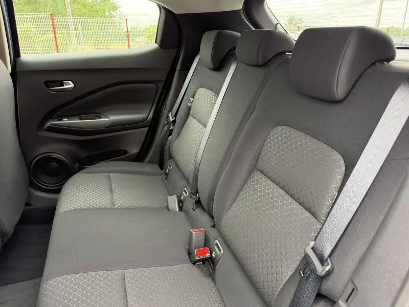 Vue intérieure de la banquette arrière noire du Nissan Juke 2025, avec ceintures de sécurité et appuie-têtes visibles.