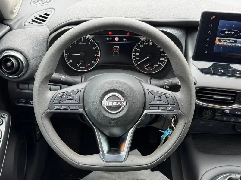 Vue centrée sur le volant multifonction noir du Nissan Juke 2025 avec tableau de bord et écran tactile visibles.