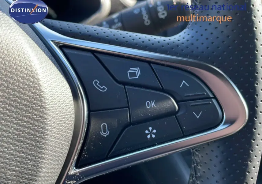 Gros plan sur les commandes multifonctions du volant en cuir perforé du Renault Symbioz noir étoile métal.