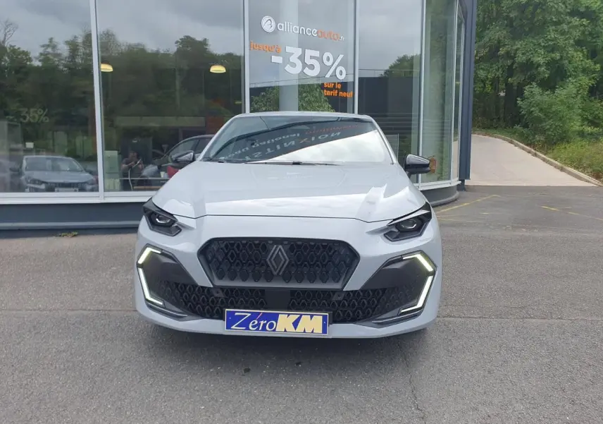 Vue avant d'une Renault Clio VI gris rafale avec calandre noire et feux LED en forme de C allumés.