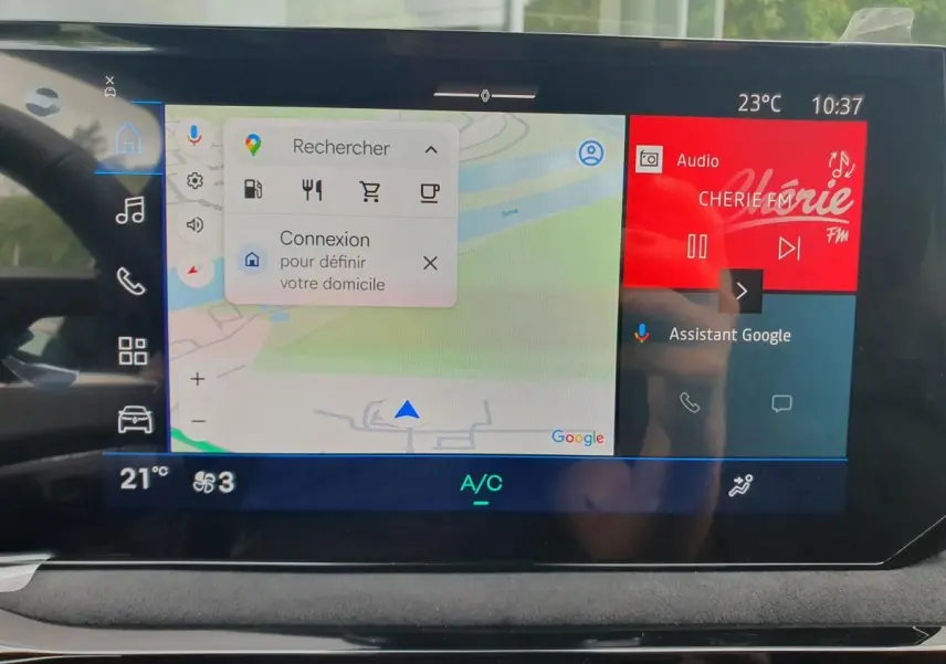 Vue intérieure du tableau de bord de la Renault Clio VI hybride avec écran tactile affichant navigation et radio.