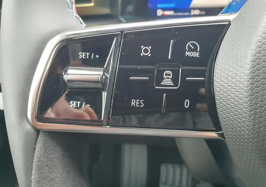 Gros plan sur les commandes de régulateur de vitesse au volant de la Renault Clio VI gris Rafale, finition Esprit Alpine.