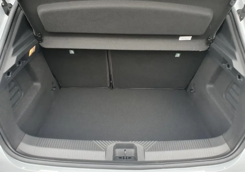 Coffre ouvert vu de l'arrière de la Renault Clio VI gris Rafale, montrant un espace de chargement propre et vide.