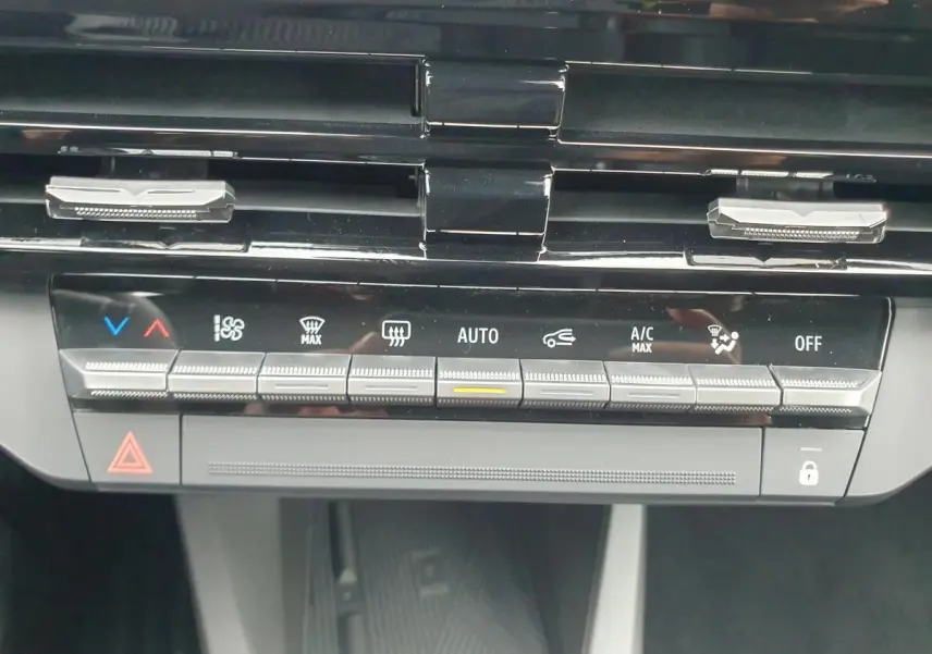 Détail de la console centrale de la Renault Clio VI hybride 2026, montrant les commandes de climatisation et ventilation.