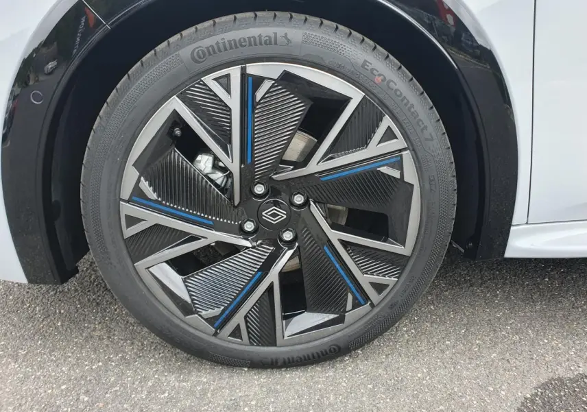 Gros plan sur la jante alliage 18” diamantée noire et bleue de la Renault Clio VI gris Rafale, pneu Continental visible.
