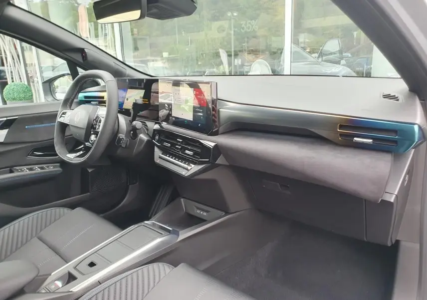 Vue intérieure côté conducteur de la Renault Clio VI hybride 2026, tableau de bord moderne avec écran tactile et volant multifonction.