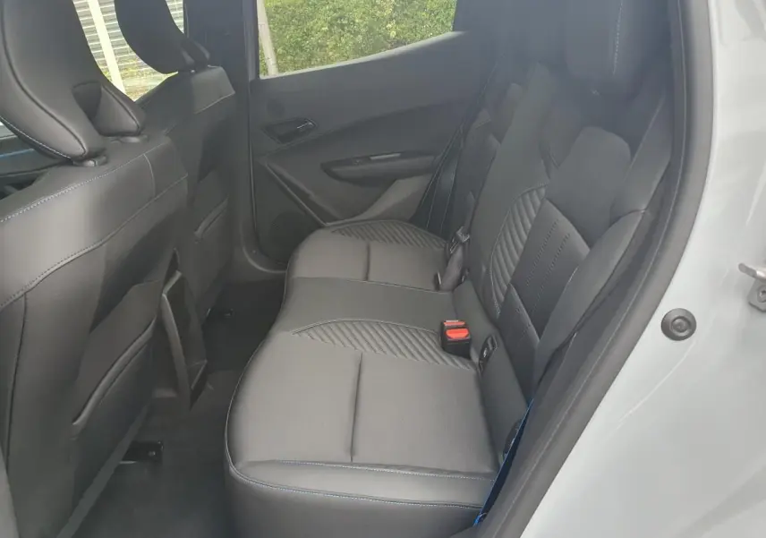 Vue côté droit des sièges arrière en tissu noir avec surpiqûres bleues d’une Renault Clio VI gris Rafale, porte ouverte.