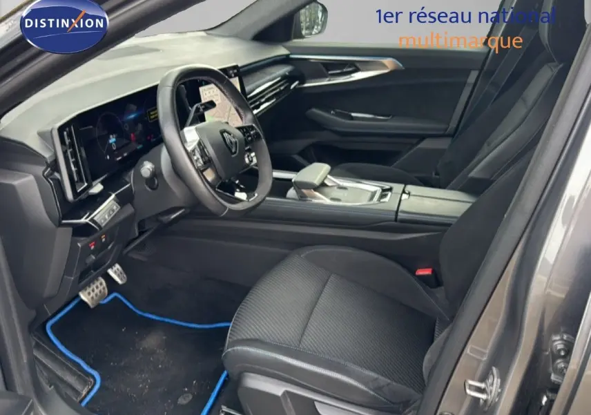 Intérieur avant droit du Renault Austral gris schiste, volant multifonctions et console centrale moderne visible.