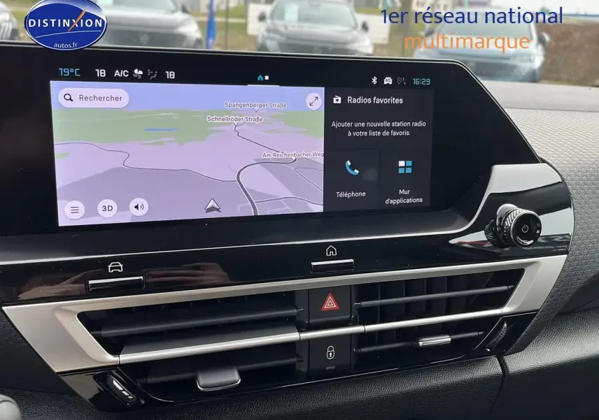Vue rapprochée de l’écran tactile et de la console centrale noire brillante du tableau de bord du Citroën C4 noir métal 2025.