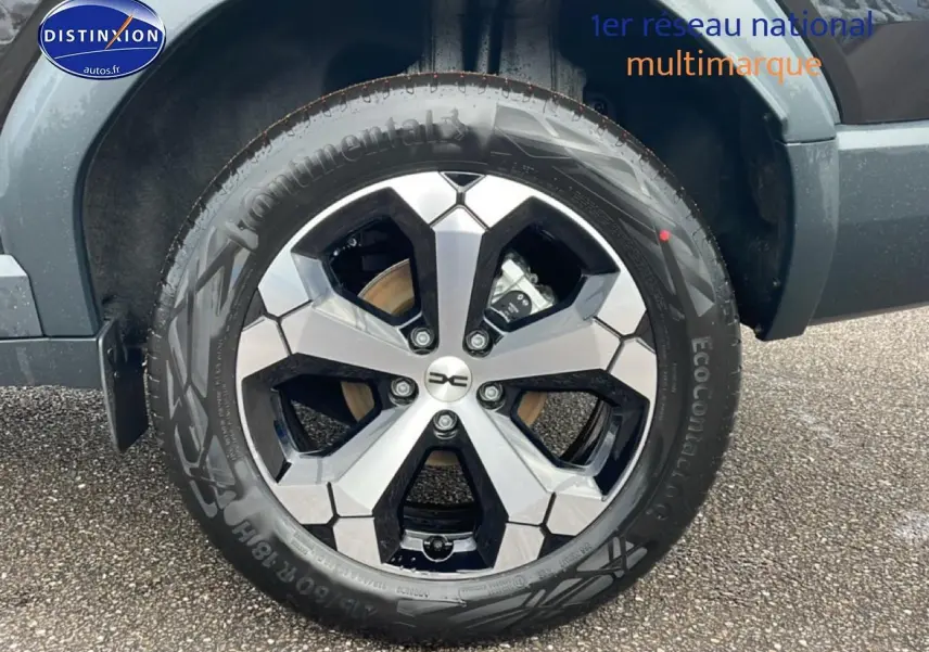 Gros plan sur la jante alliage diamantée 18 pouces du Dacia Bigster noir, avec pneu Continental et partie d'aile visible.