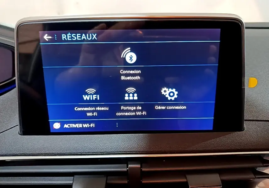 Écran tactile central du tableau de bord du Peugeot 3008 gris clair, affichant les options de connexion Wi-Fi et Bluetooth.