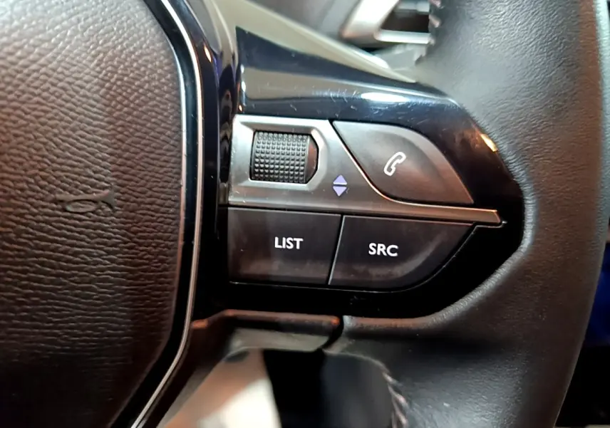 Gros plan sur les commandes gauche du volant cuir noir du Peugeot 3008 gris clair, version Puretech 130 S&S Active Business.