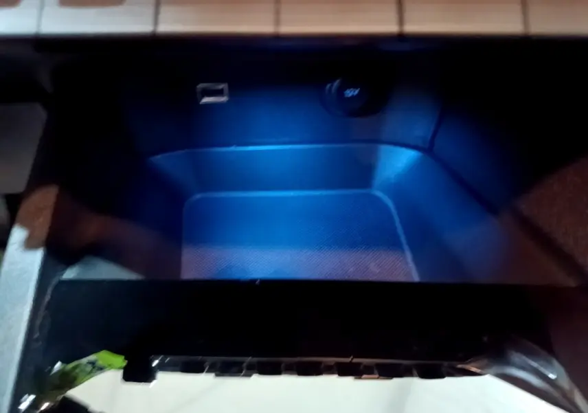 Gros plan sur la prise USB et prise 12V dans le compartiment de rangement intérieur du Peugeot 3008 gris clair.