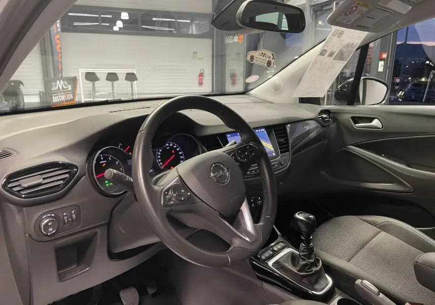 Vue intérieure côté conducteur de l’Opel Crossland 2024, volant cuir et tableau de bord avec écran tactile.