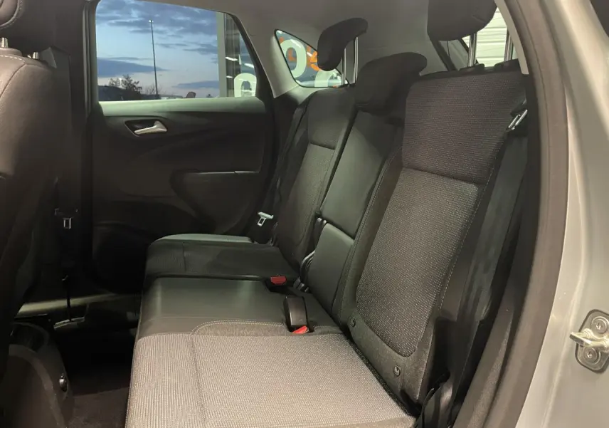 Vue intérieure côté droit de la banquette arrière en tissu gris foncé de l’Opel Crossland gris clair 2024.