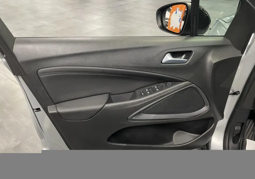 Vue intérieure de la porte avant gauche gris clair de l’Opel Crossland avec commandes électriques et haut-parleur intégré.
