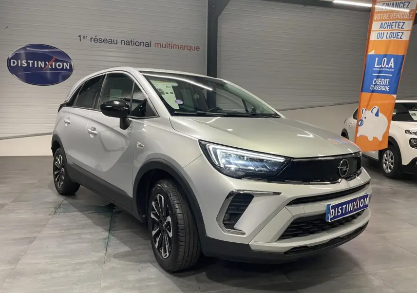 Opel Crossland gris clair en 3/4 avant droit, avec jantes alliage diamantées et calandre noire brillante.