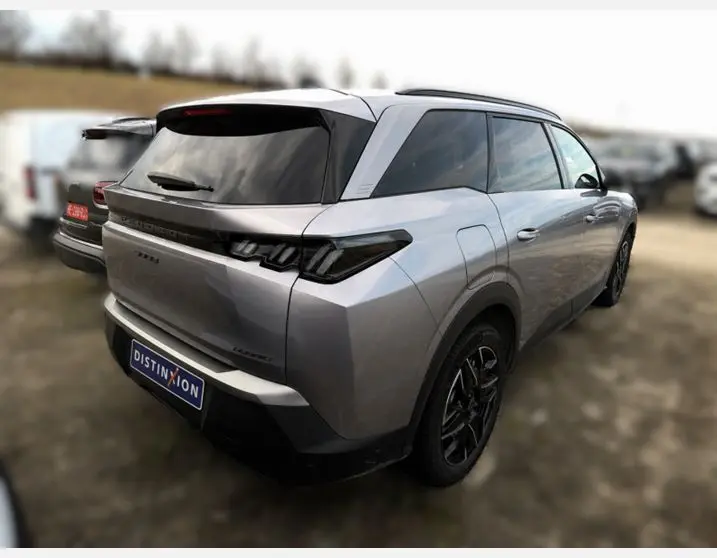 Vue 3/4 arrière droite du Peugeot 5008 gris Artense avec vitres teintées et jantes noires distinctives.