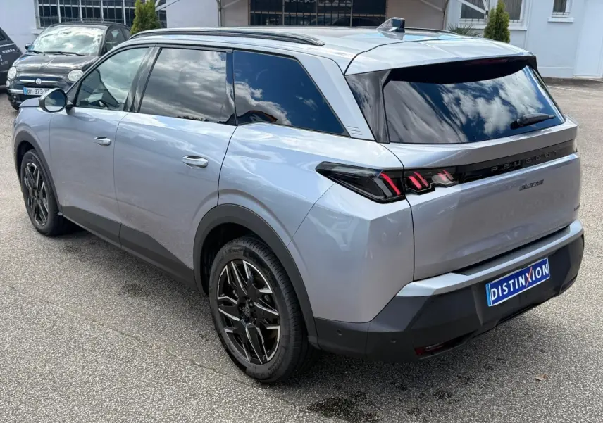 Peugeot 5008 Hybrid gris Artense vue 3/4 arrière droit, avec vitres teintées et jantes noires distinctives.