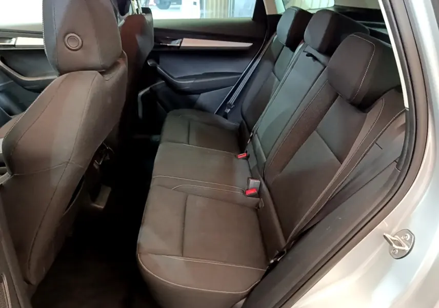 Vue intérieure côté droit des sièges arrière noirs du Skoda Karoq 1.5 TSI 2022 avec ceinture de sécurité visible.