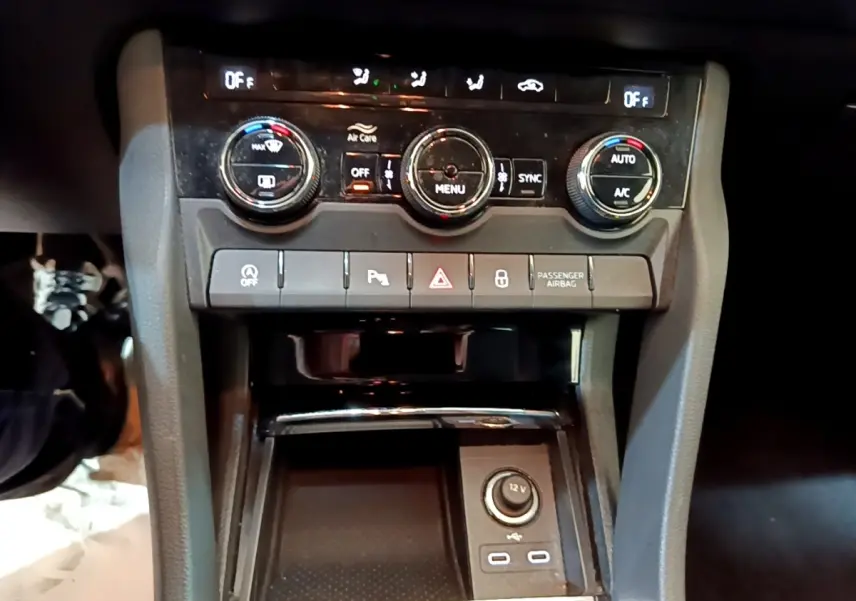 Vue rapprochée de la console centrale du Skoda Karoq 2022, avec commandes climatisation et prises USB visibles.