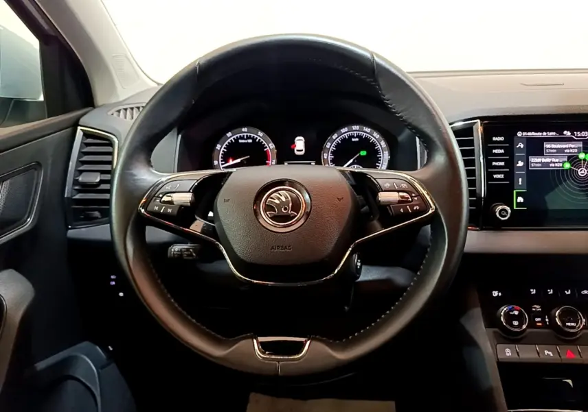 Vue centrée sur le volant cuir noir du Skoda Karoq 2022 avec tableau de bord digital et écran tactile à droite.