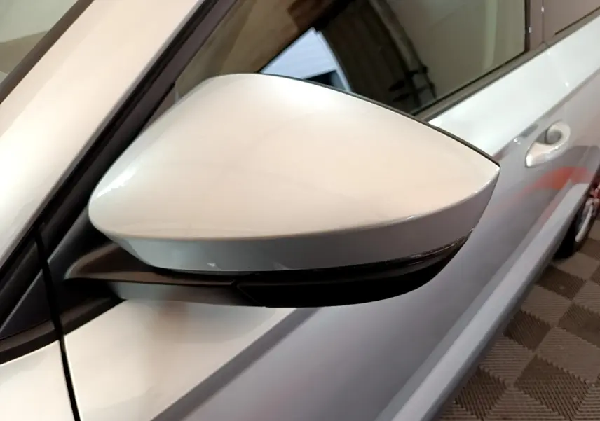 Rétroviseur droit gris clair du Skoda Karoq 2022, vue rapprochée sur la portière et poignée côté droit.