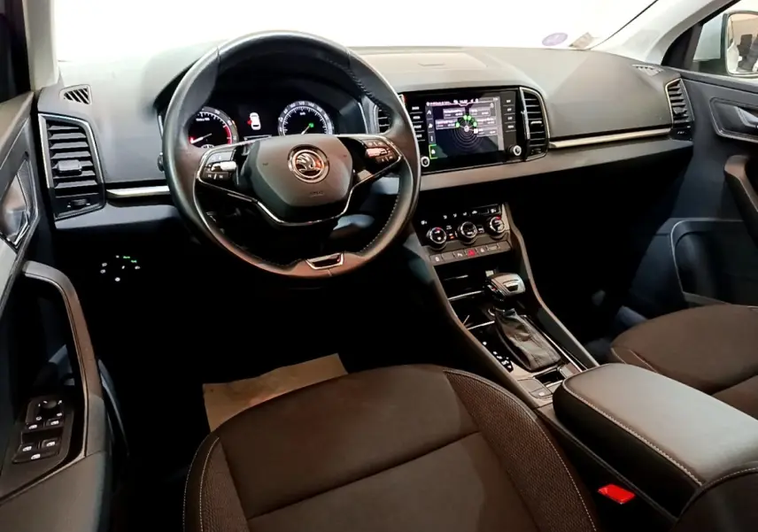 Vue intérieure du poste de conduite du Skoda Karoq 2022, avec tableau de bord numérique et écran tactile central.
