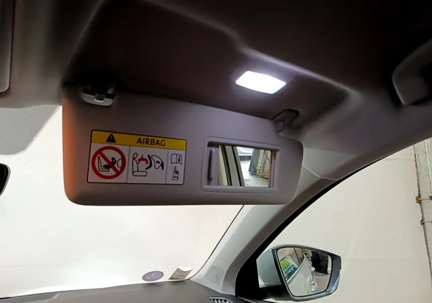 Vue intérieure du pare-soleil côté conducteur avec miroir et avertissement airbag sur Skoda Karoq gris clair 2022.