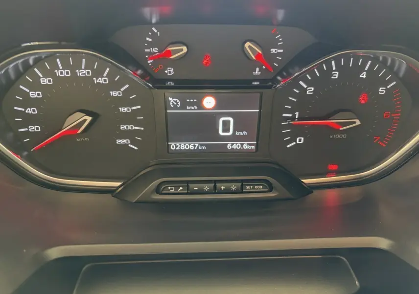 Vue rapprochée du tableau de bord numérique du Peugeot Rifter PureTech 110 blanc, affichant la vitesse à 0 km/h.