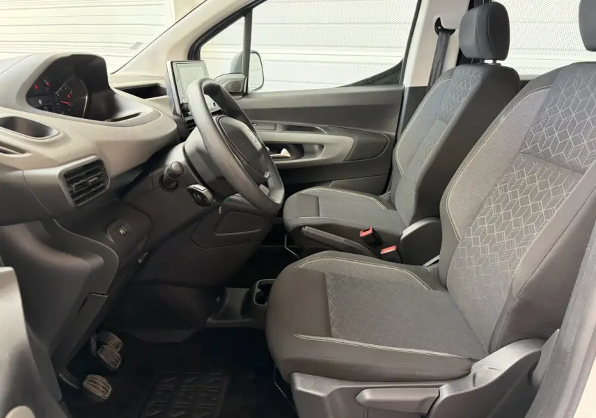 Vue intérieure côté conducteur du Peugeot Rifter 2021, sièges tissu gris et volant multifonctions noir.