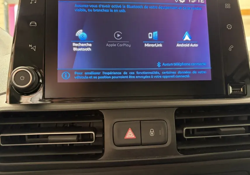 Écran tactile central du tableau de bord du Peugeot Rifter blanc 2021 affichant les options Bluetooth, Apple CarPlay et Android Auto.