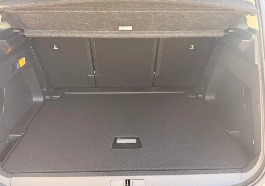 Coffre ouvert vu de l'arrière d'un Citroën C5 Aircross gris Platinium, espace de chargement plat et tapis noir.