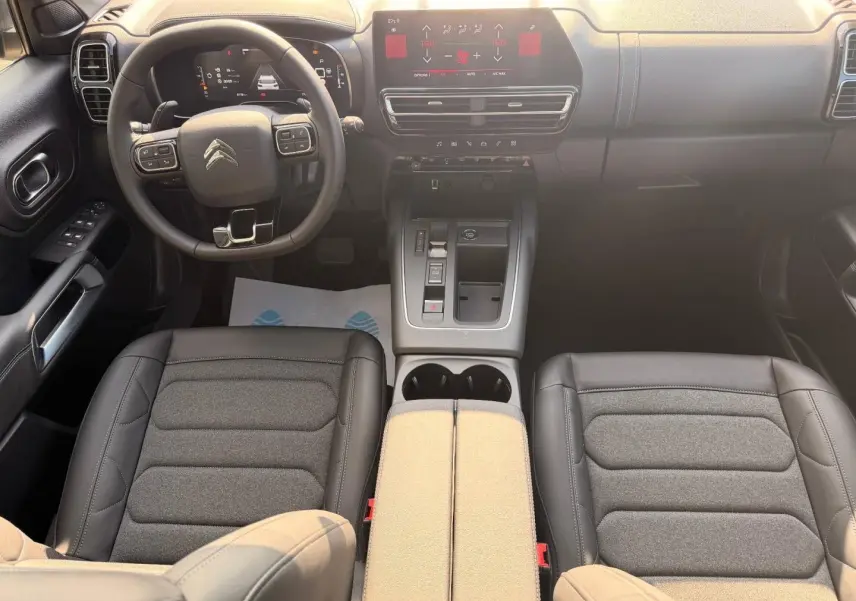 Vue intérieure avant du Citroën C5 Aircross 2025 montrant le volant cuir multifonction et la console centrale avec écran tactile.