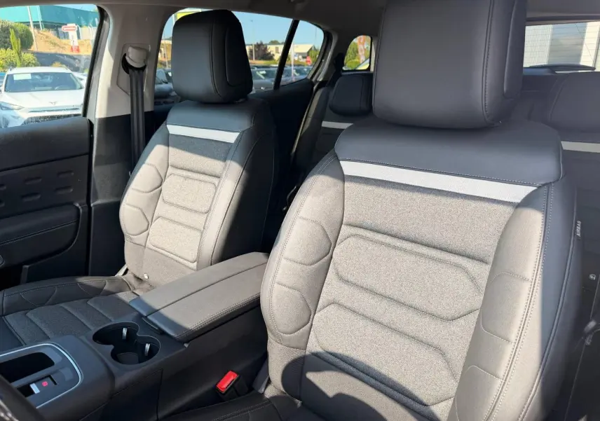 Vue intérieure côté droit des sièges avant en tissu noir et gris du Citroën C5 Aircross 2025 avec accoudoir central.