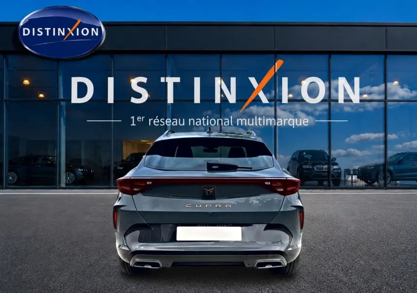 Vue arrière d'une CUPRA Formentor bleu fjord garée devant une vitrine avec logo Distinxion.