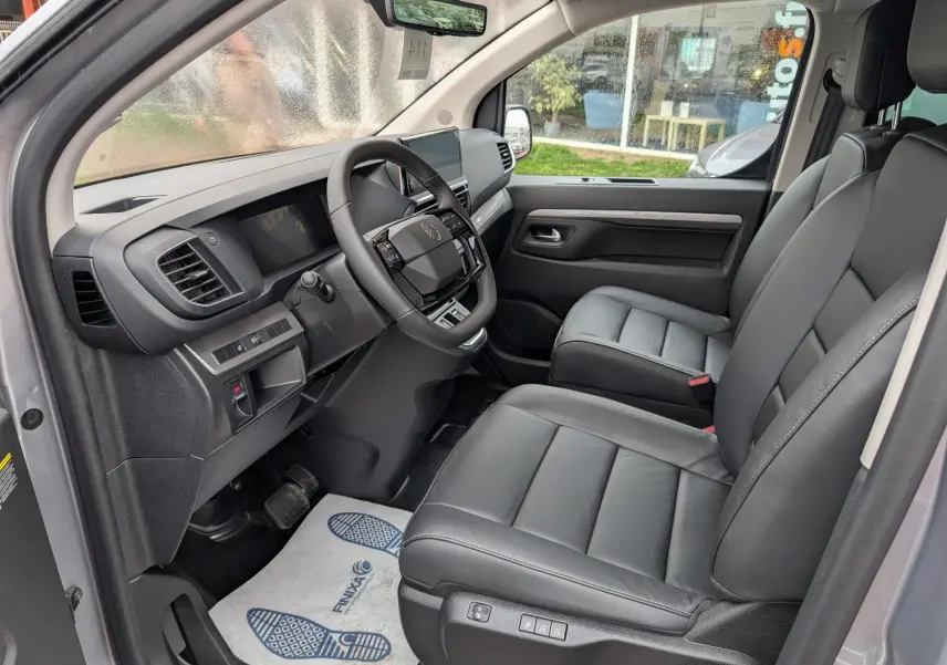 Intérieur avant droit du Citroën Jumpy gris 2026, sièges cuir noirs et tableau de bord avec écran tactile.