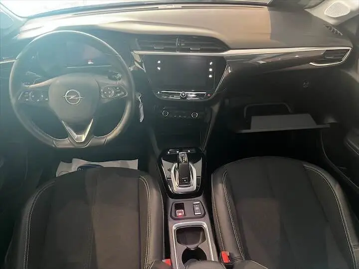 Intérieur de l'Opel Corsa gris métal 2021 vu de face, tableau de bord moderne avec écran tactile et volant multifonctions.