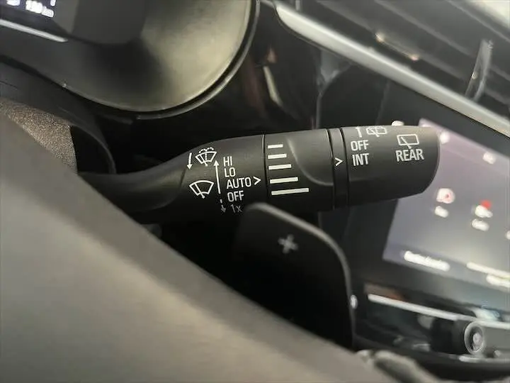 Gros plan sur la commande d'essuie-glace à gauche du volant dans l'habitacle d'une Opel Corsa gris métal 2021.