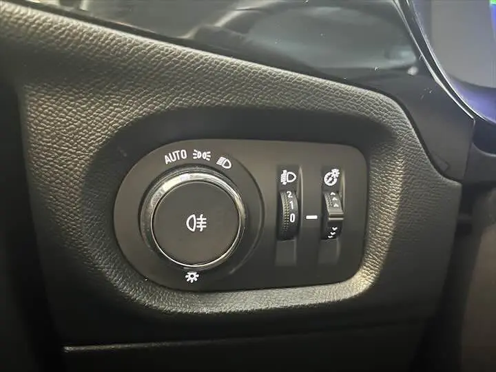 Gros plan sur le panneau de commande des phares et réglages lumineux de l'Opel Corsa gris métal 2021.