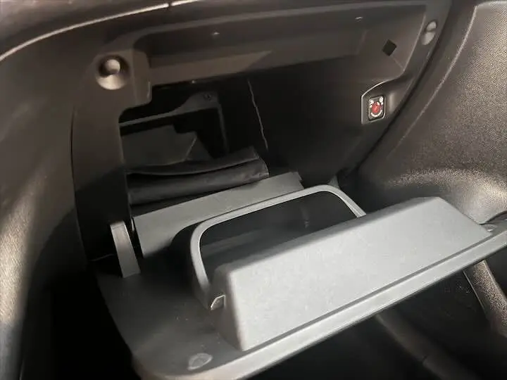 Ouverture de la boîte à gants noire à l'intérieur de l'Opel Corsa gris métal, version Elegance 2021.