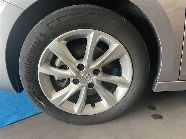 Gros plan sur la roue avant droite grise d'une Opel Corsa 1.2T 100 CH Elegance BVA8 avec jante alu et pneu Continental.