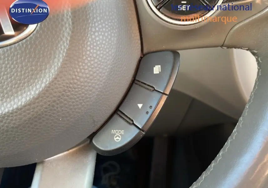 Gros plan sur les commandes au volant en plastique noir et cuir gris d’un Kia Soul EV électrique 2016.