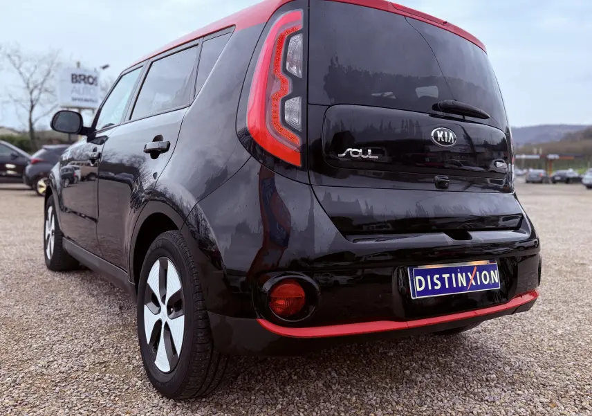 Vue 3/4 avant d'une KIA Soul EV électrique 2016 noire avec toit et détails rouges, sur fond neutre.